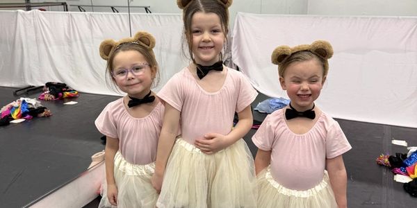 Three girls in bear-themed ballet costumes.