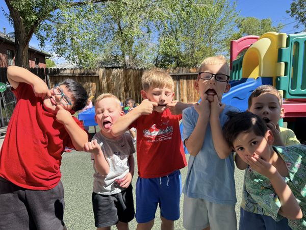 Group of kids making funny faces outside.