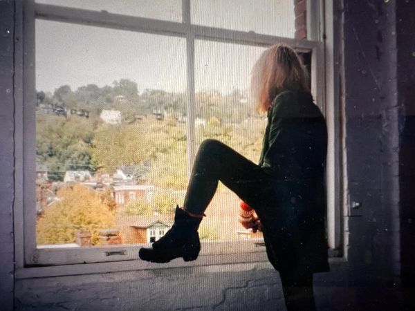 Greer Lankton in 1996 looking out the window at the Mattress Factory Museum. 