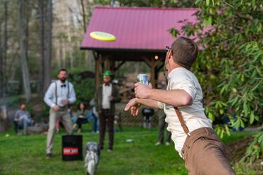 Wedding guests play yard games at an outdoor reception.