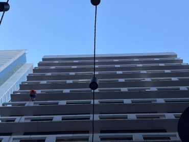Person rappelling down a tall building.