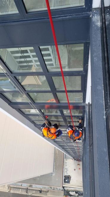 Two workers cleaning high-rise building windows.