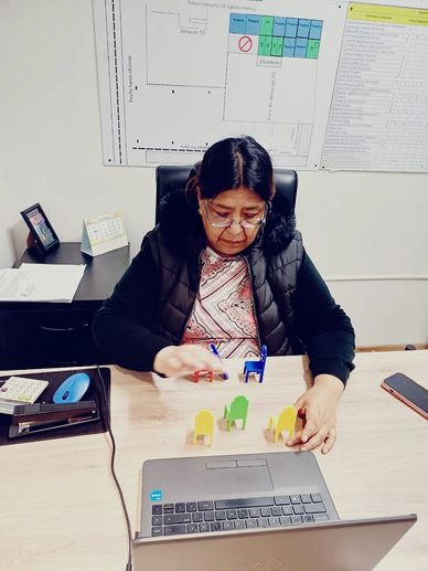 Woman playing with colorful wooden blocks at her desk.