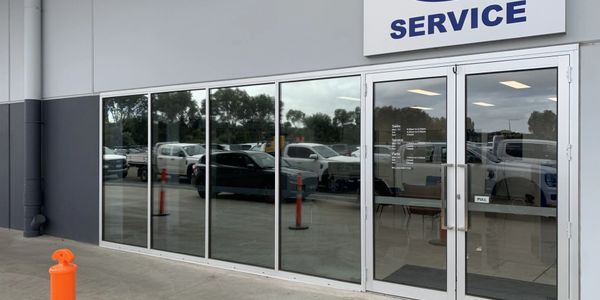 Reflective glass windows and doors at a service center entrance.