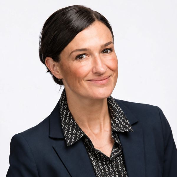 Professional woman in navy blazer with a subtle smile.