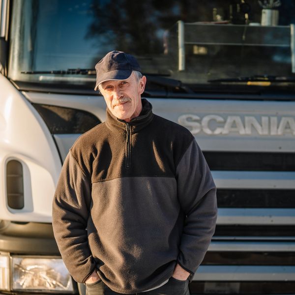 Man standing in front of a large truck.