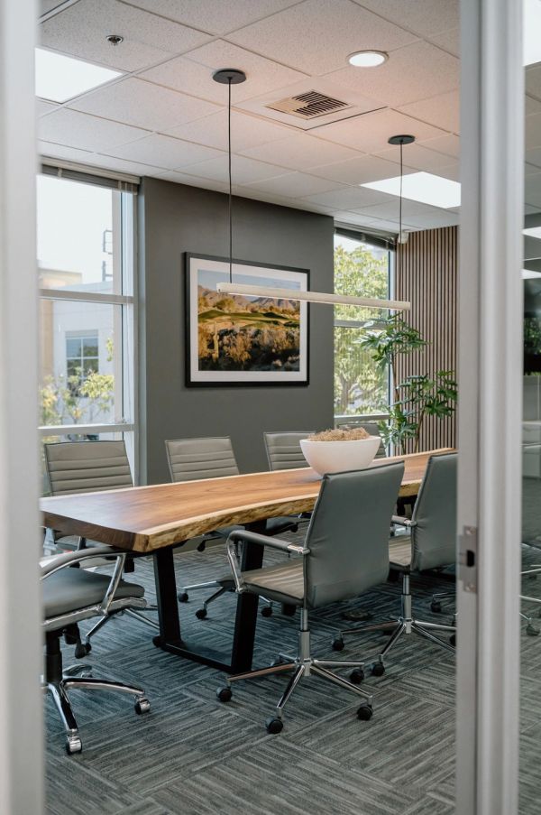 Office conference room, charcoal walls, wood desk, art piece