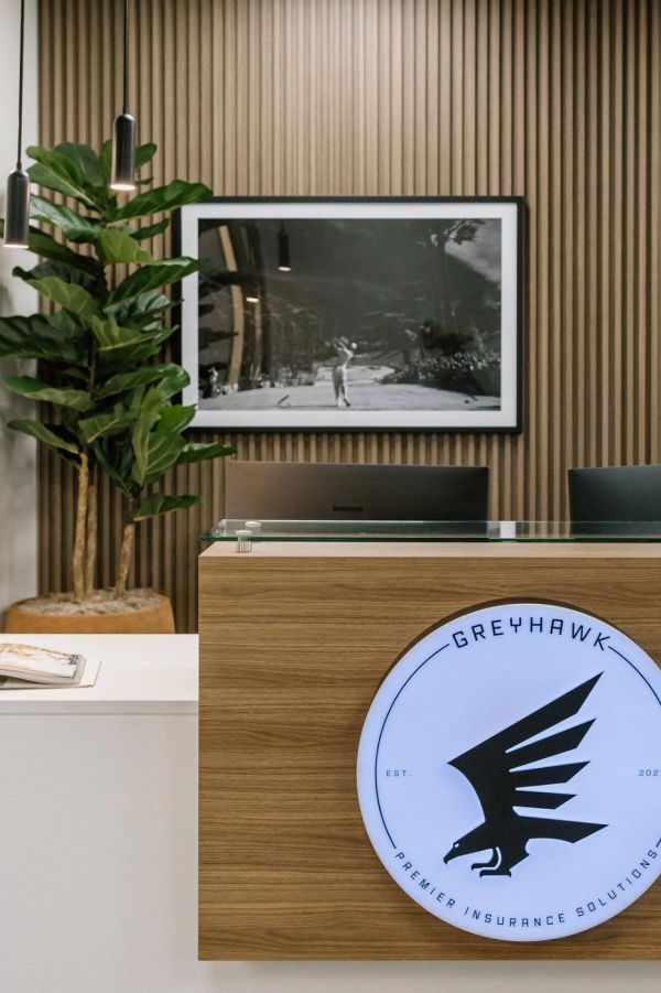 Commercial space reception desk with wood accent and LED logo