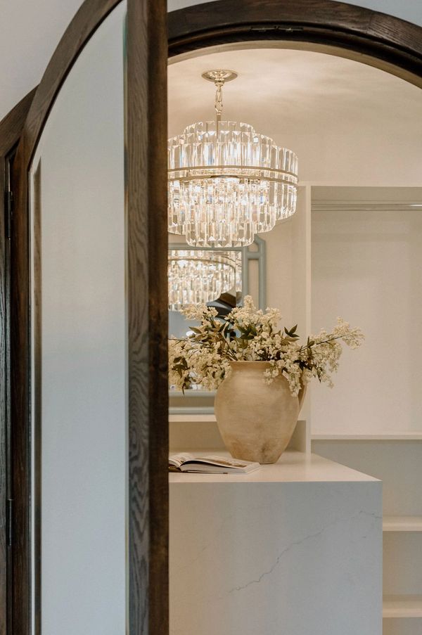 Wood arched doors going into closet, closet chandelier crystal