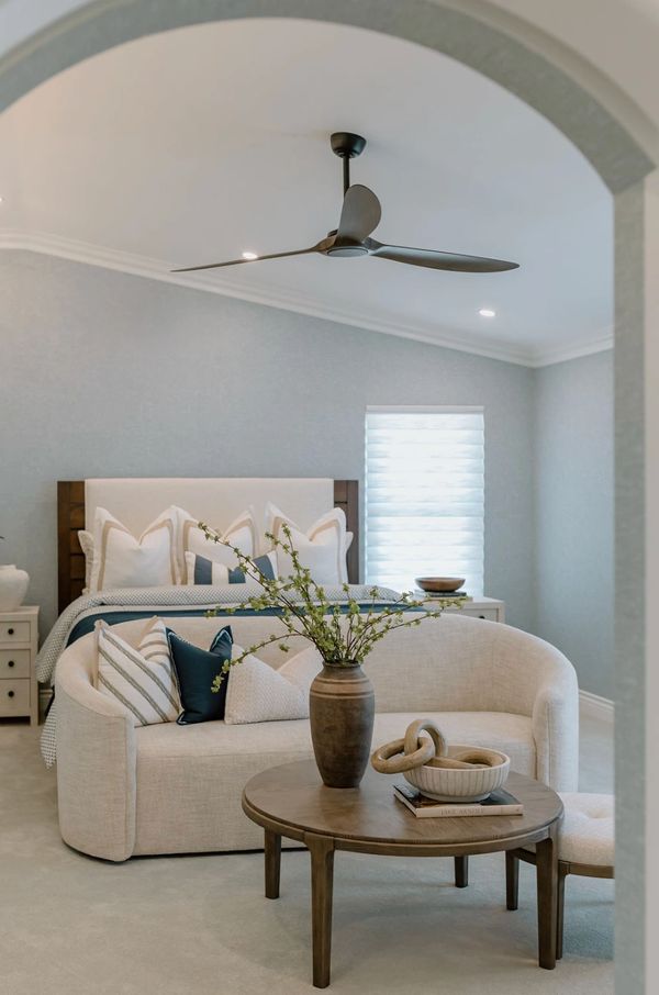Coastal bedroom with blue wallpaper, sofa and ottoman
