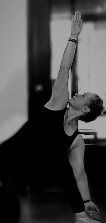 Woman practicing yoga in a side stretch pose indoors.