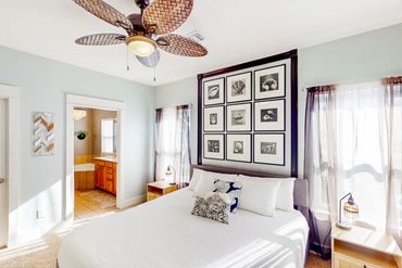 Florida vacation home Master Suite with ceiling fan, coastal decor, bed lamps,