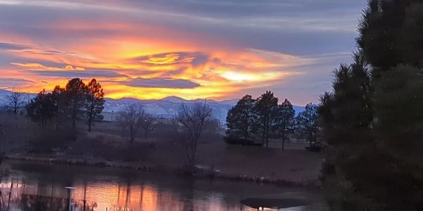 Image of Sunset and clouds over the rocky mountains with a lake in the foreground