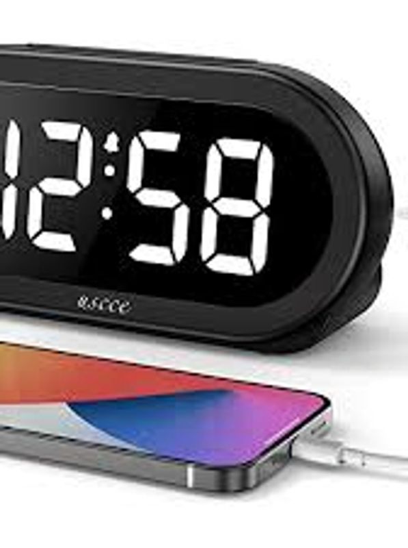 Digital clock showing 12:58 with phone charging.