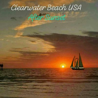 Sailboat glides on calm waters at Clearwater Beach after sunset.