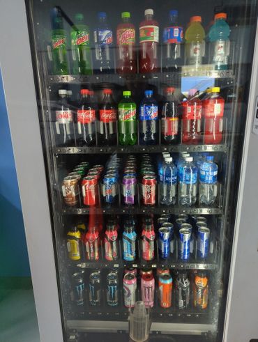 A vending machine filled with various sodas, energy drinks, and bottled water.