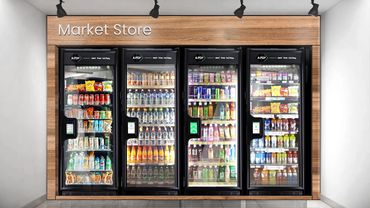 Four glass-door refrigerators stocked with drinks and snacks in a modern market store.