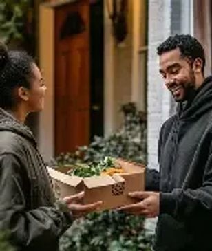 A man receiving a box of groceries from a woman.
