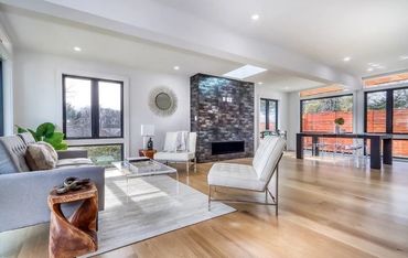 Single family living space with brand new fireplace, hardwood flooring, and new window walls