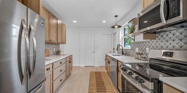 Modern kitchen with stainless steel appliances and wooden cabinets.