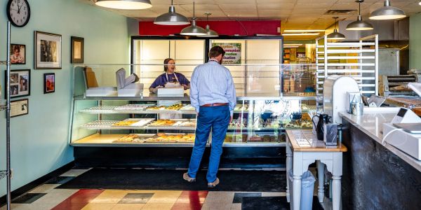 Man ordering at a bakery counter.