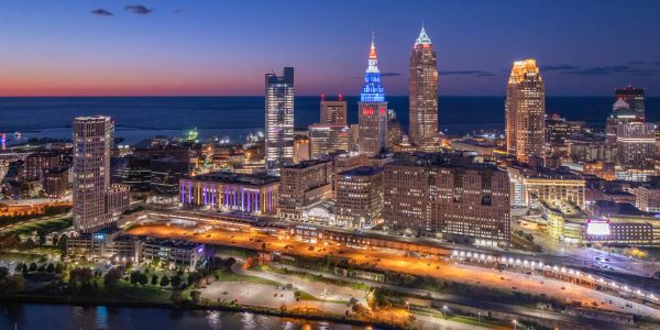 City skyline at dusk with illuminated buildings and waterfront.