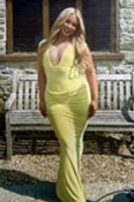 Woman in a yellow dress standing outdoors.