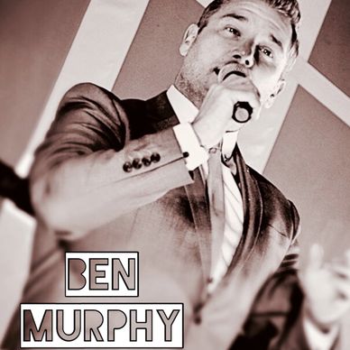 Man in suit speaking into a microphone.