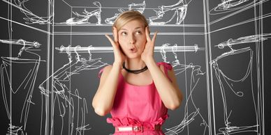A surprised woman in a pink dress stands in front of a closet sketch.