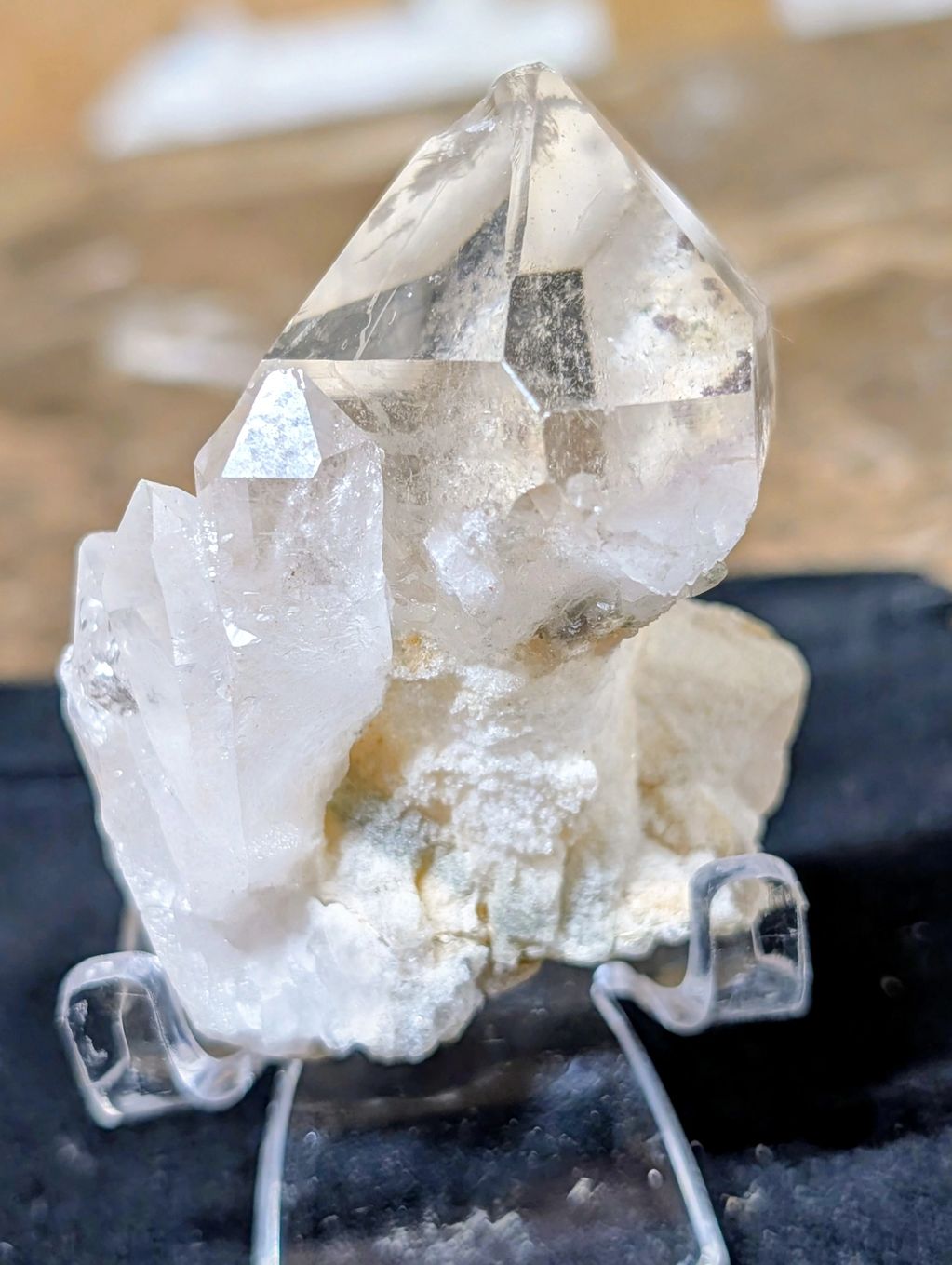 Clear quartz crystal cluster on display stand.