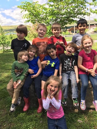A cheerful group of children posing outdoors on a sunny day.