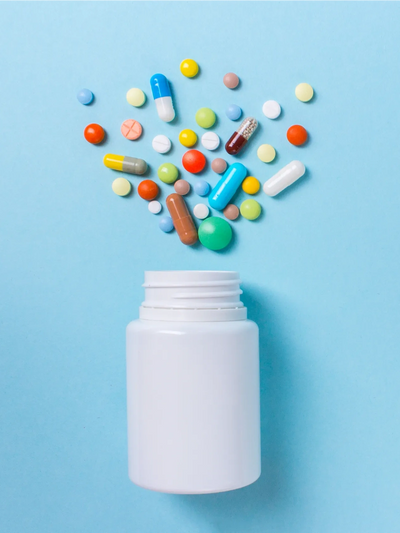 A variety of psychiatric medications laid out next to a pill bottle aesthetically