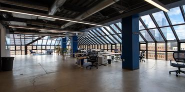 Spacious modern office with floor-to-ceiling windows and city views.