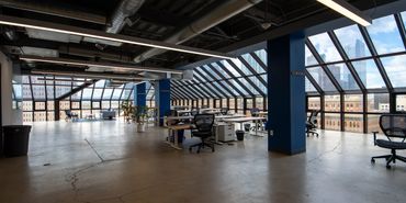 Modern open office space with large windows and city views.