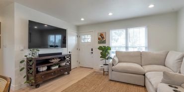 Cozy living room with a large beige sectional sofa and a mounted TV.