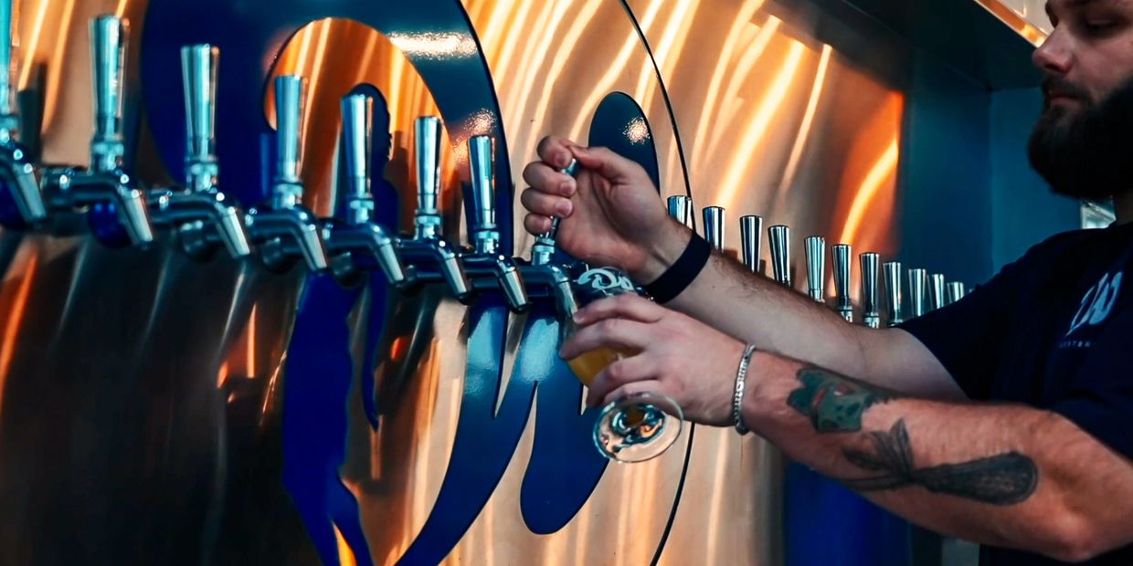 Westbrew bartender pouring a cold craft beer off the draft system.