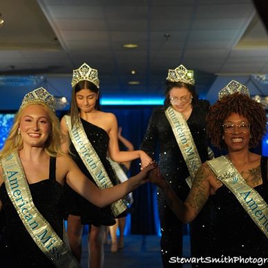 AMP Queens smiling with crown and banners as they walk down the runway. 