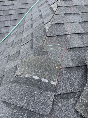 Close-up of a roof with asphalt shingles and nail patches.