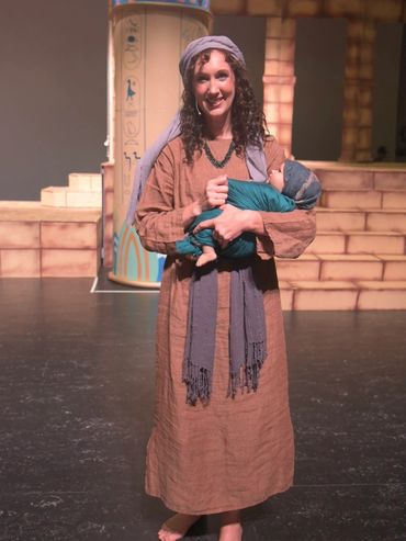 Miriam smiling and holding baby Moses