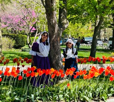 Mother and daughter in Dutch costumes by tulips