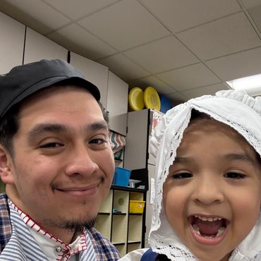 Close up picture of smiling father and daughter wearing Dutch hats