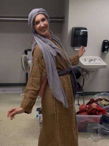 Actress in tan linen tunic with lavender headscarf - Prince of Egypt