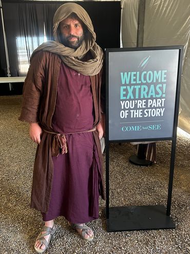 Male extra in The Chosen movie, standing by welcome sign