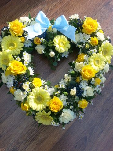 An open heart funeral tribute - loose filled with seasonal flowers