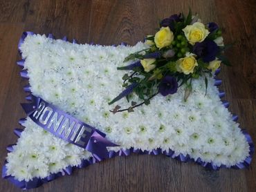 A personalised pillow tribute. Based with white Chrysanthemums and a purple & yellow spray.