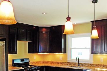 Modern kitchen with dark cabinets and granite countertops.