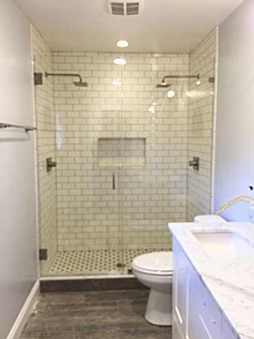 Modern bathroom with dual shower heads and subway tile.