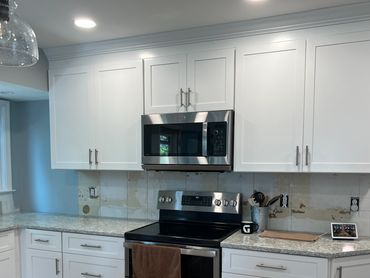Modern kitchen with white cabinets and granite countertops.