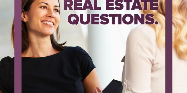 Two women discussing real estate questions in a professional setting.