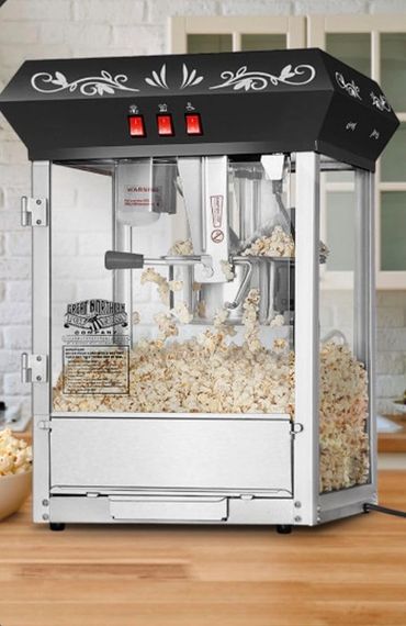 A vintage-style popcorn machine filled with freshly popped popcorn.